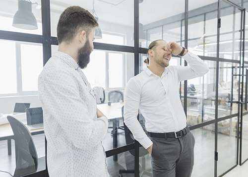Dos hombres teniendo una charla de pasillo en su lugar de trabajo